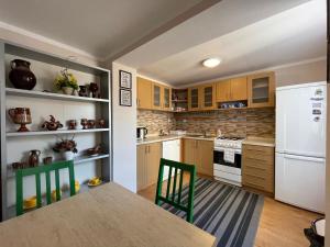 a kitchen with a table and a white refrigerator at Apartmán Stráne in Martin