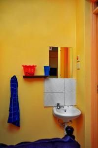 Baño amarillo con lavabo y espejo en Attic Place South B, en Nairobi