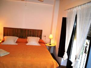 1 dormitorio con 1 cama grande de color naranja y ventana en Cal Valeri en Montsonis