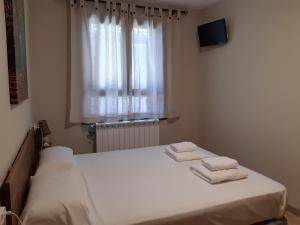 a bedroom with a bed with two towels on it at Apartamento familiar con vistas y garage La Portiecha in Sallent de Gállego