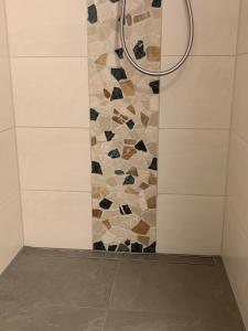 a shower with a stone wall and a shower head at Sprem06 in Elsterheide
