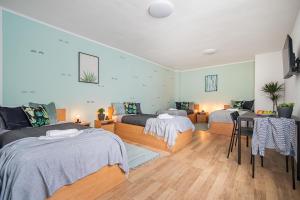 a bedroom with two beds and a table and chairs at Penzion Village Peace #29 by Goodnite cz - U Libušky in Brno