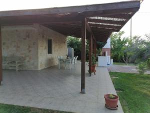 un patio coperto con tavolo e sedie di Villa DI GRASSI - Locazione Turistica a Polignano a Mare