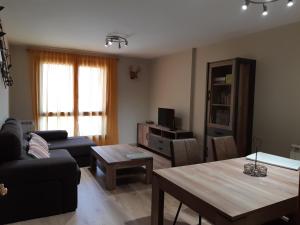 - un salon avec un canapé et une table dans l'établissement Apartamento familiar con vistas y garage La Portiecha, à Sallent de Gállego