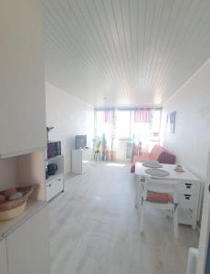 a white living room with a table and a couch at Coquet studio au centre port du Cap d'Agde in Cap d'Agde