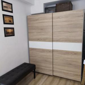 uma grande cómoda de madeira num quarto com um banco em Apartament Morskie Polanki em Kolobrzeg