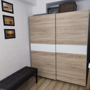 Vestidor de madera grande en una habitación con banco en Apartament Morskie Polanki, en Kołobrzeg 61 fotos más