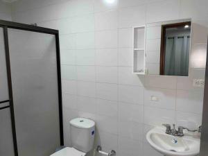 a white bathroom with a toilet and a sink at CIC APARTAMENTO CASTELLANA 3PISO PARQUEADERO GRATIS in Montería +6 photos