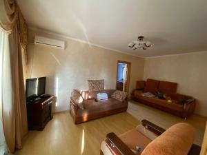 a living room with a couch and a tv at Apartment on Abazgaa in Gagra