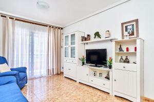 a living room with a blue couch and a tv at Espanhouse David 2 bedroom apartment Torrevieja with pool in Torrevieja