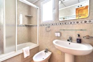 a bathroom with a sink and a toilet and a mirror at Espanhouse David 2 bedroom apartment Torrevieja with pool in Torrevieja +14 photos