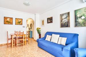 a living room with a blue couch and a table at Espanhouse David 2 bedroom apartment Torrevieja with pool in Torrevieja
