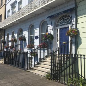 a building with a blue door and stairs with flowers at Norfolk Hotel in Weymouth