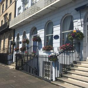 a building with flower boxes on the windows and stairs at Norfolk Hotel in Weymouth +34 photos