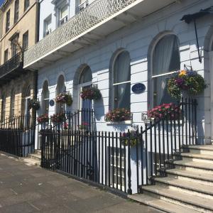 a white building with flower boxes on the windows at Norfolk Hotel in Weymouth
