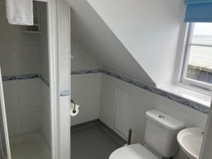 a white bathroom with a toilet and a sink at Norfolk Hotel in Weymouth