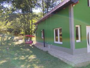 een groen huis met een persoon die onder een paraplu zit bij Green House in Rijeka