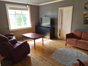 salon z telewizorem, kanapą i stołem w obiekcie The old house w mieście Selfoss