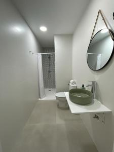 baño con lavabo verde y espejo en Merkat Center Alicante en Alicante