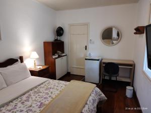 a bedroom with a bed and a desk and a chair at Estalagem do Rancho in Itatiaia