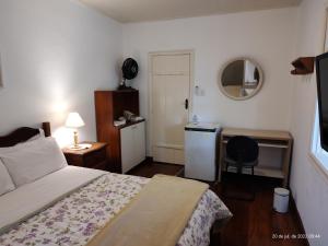 a bedroom with a bed and a desk and a chair at Rancho São Carlos in Itatiaia