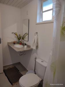 a white bathroom with a toilet and a sink at Rancho São Carlos in Itatiaia