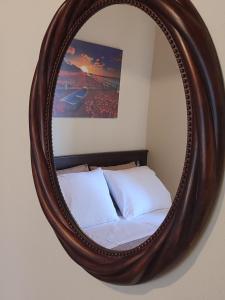 a mirror hanging on a wall with a bed at La Casa De Vacation in Lafkos