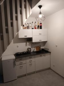 a small kitchen with white cabinets and a sink at Domki nad jeziorem w Borach Tucholskich in Skorzenno
