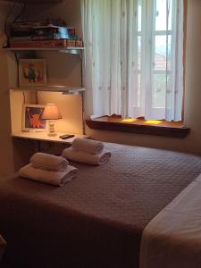 a bedroom with a bed and a window with a lamp at La Casa De Vacation in Lafkos