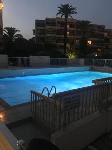 duży basen z niebieską wodą w nocy w obiekcie Golfe Juan, quiet apartment with pool, near the beach w mieście Vallauris