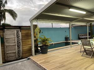 un pavillon avec une terrasse et une piscine dans l'établissement Ti Kaz Fantaisie, à Le Patelin