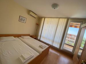 a bedroom with a bed and a large window at Nessebar Fort Club Apartment 226 in Sunny Beach