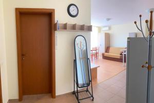 a room with a refrigerator and a clock on a wall at Nessebar Fort Club Apartment 226 in Sunny Beach