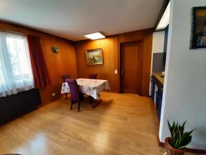 Chalet apartment by Interlaken. Parking في رينغنبرغ: غرفة طعام مع طاولة وكراسي ونافذة