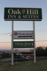 a sign for an oak hill inn and suites at Oak Hill Inn and Suites in Tahlequah