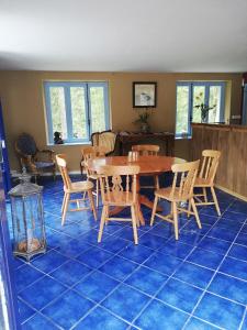 een eetkamer met een tafel en stoelen op een blauwe tegelvloer bij Chambre d'hôte Moulin du Breuil. in Pionnat