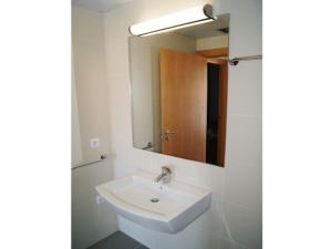 a white bathroom with a sink and a mirror at Urpa Apartaments in Llança +28 photos