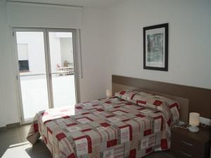 um quarto com uma cama com uma colcha em Urpa Apartaments em Llançà