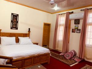 a bedroom with a large white bed and two windows at Bottleneck Lodges in Gilgit +11 photos