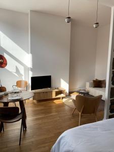 a bedroom with a bed and a living room with a tv at Appart POP 1 Centre ville calme avec parking in Arras
