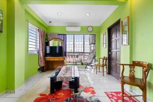 sala de estar con paredes verdes y mesa en 3 scenic air cond bedrooms, 11 minutes Rawang City en Rawang