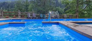 a swimming pool with blue water and chairs in it at Pigy in Tatariv