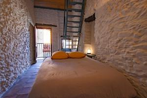 1 dormitorio con 1 cama grande en una pared de piedra en La Marinade, en Banyuls-sur-Mer