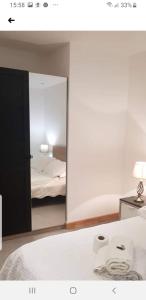 a bedroom with a mirror with a bed and a lamp at Jadwin Beautiful Room Share toilet 2 people in London