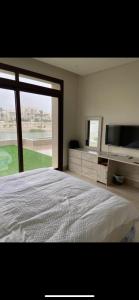 um quarto com uma cama grande e uma janela grande em Hawana Salalah Villa Lake View em Salalah