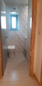 a bathroom with a toilet and a window at Jadwin Beautiful Room Share toilet 2 people in London