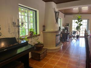 a living room with a fireplace and a piano at Quinta do Vale Encantado "the Valley" - Santarém - Portugal in Calhariz