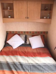 a bed in a small room with two pillows at Pant yr onen holidays in Llandrindod Wells