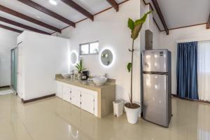 a bathroom with a sink and a refrigerator at The Babylon Suite Tortuguero in Tortuguero