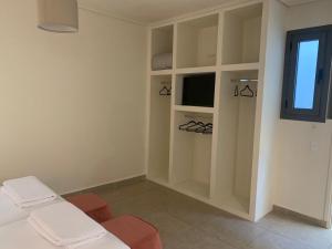 um quarto com uma cama, uma televisão e uma janela em Lavender Villas Agios Nikitas , Lefkada em Ayios Nikitas